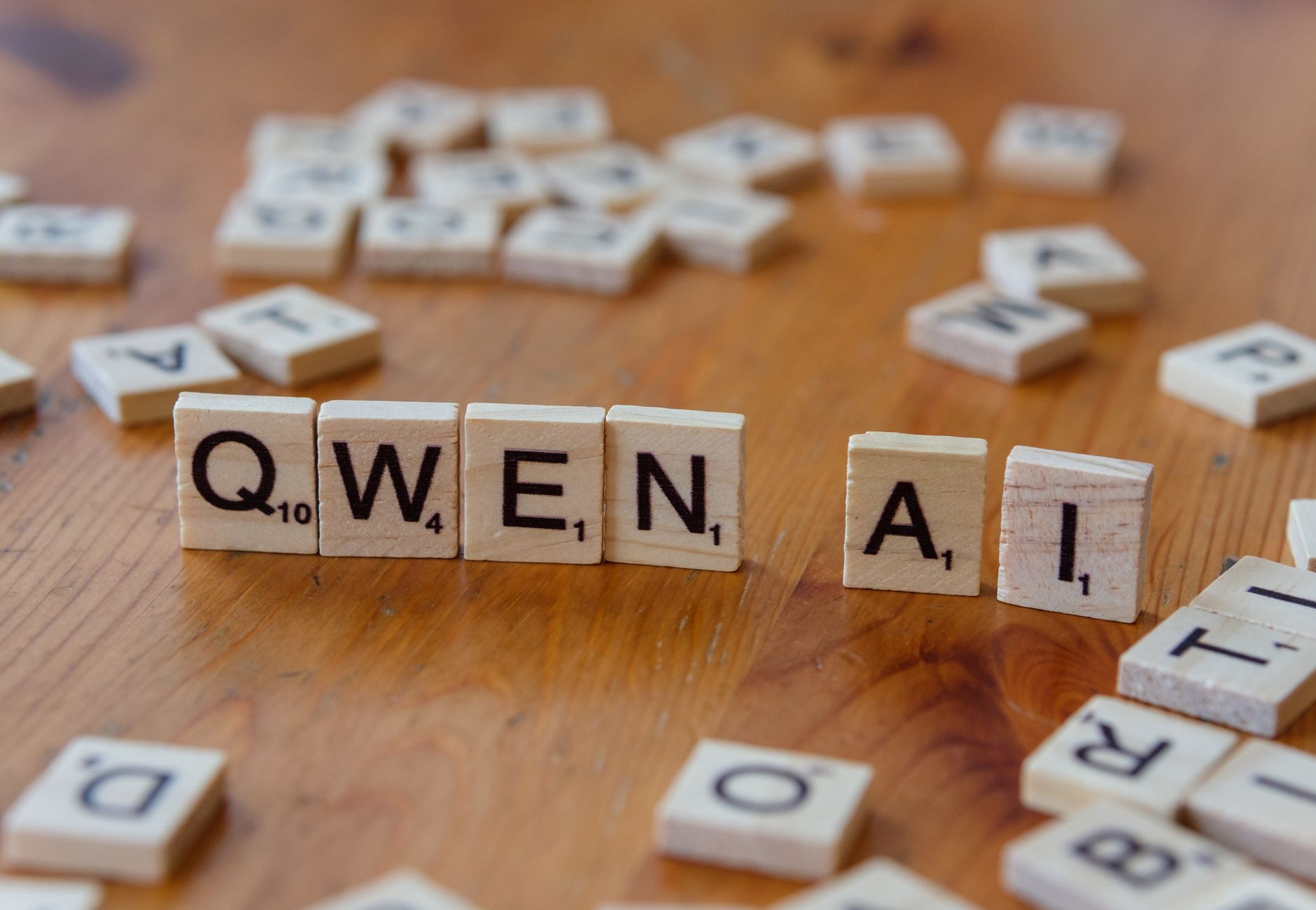 Scrabble-like tiles arranged to spell 'Qwen AI' on a wooden surface, depicting technology concepts.