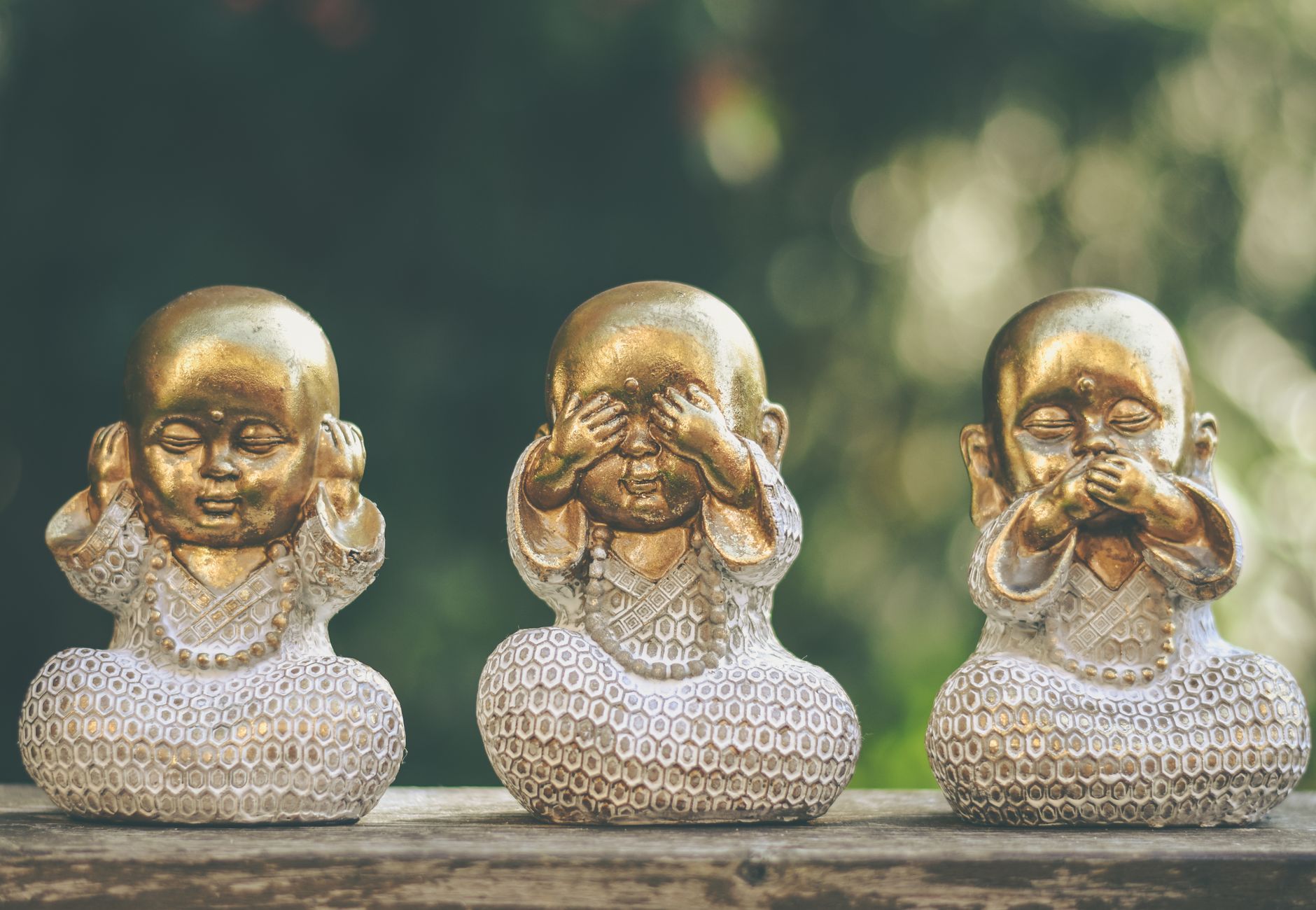 Golden Buddha statues depicting hear no evil, see no evil, speak no evil concept. Perfect for meditation and mindfulness themes.